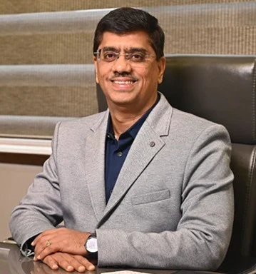 Sunil Umrani, Director of IRIX Technologies, seated at a desk in a grey blazer